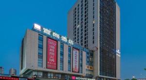 un edificio alto con letreros a un lado. en Echarm Hotel Hefei West Qilitang Metro Station, en Hefei
