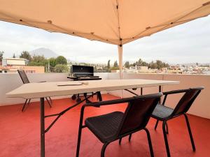 a table and chairs with an umbrella on a balcony at Dúplex céntrico y amplio, terraza cochera free in Arequipa