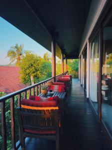 eine Reihe von Bänken auf einer Veranda in der Unterkunft SeaView Villa Tropicana in Salad Beach