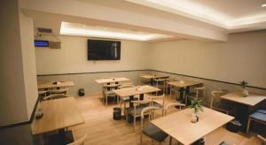 Un aula con mesas y sillas y un televisor de pantalla plana. en GreenTree Inn Express Datong High-Speed Railway Station Old City Wall, en Datong