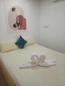 a white bed with two white towels on it at Airport Transit Motel in Katunayaka +18 photos