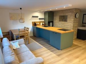 ein Wohnzimmer mit Sofa und eine Küche in der Unterkunft Ferienwohnung am Ith in Eschershausen