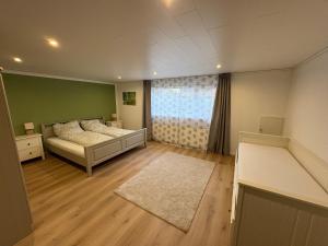 a bedroom with two beds and a large window at Ferienwohnung am Ith in Eschershausen