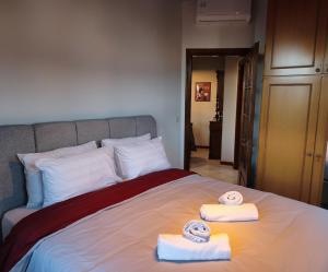 ein Schlafzimmer mit einem Bett, auf dem zwei Handtücher liegen in der Unterkunft Αρχοντικό Βιζυηνού in Xánthi