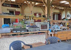 eine Küche mit einem Herd und einer Theke mit Stühlen in der Unterkunft ENTRE ADOUR et MONTAGNE in Pouillon