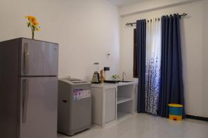 een kleine keuken met een koelkast en een tafel bij Villa Hideout in Unawatuna +24 foto's