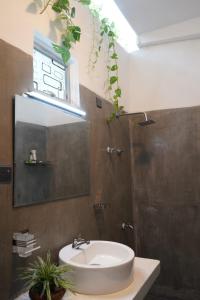 een badkamer met een wastafel en een spiegel bij Villa Hideout in Unawatuna