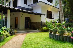 een huis met een tuin met potplanten bij Villa Hideout in Unawatuna