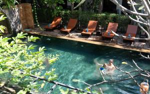a man is in the water in a swimming pool at The Moon Residence & Spa in Siem Reap