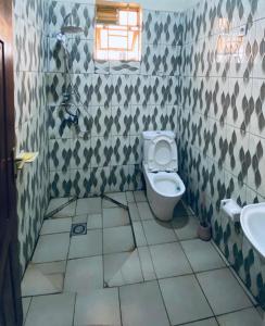 een badkamer met toilet en wastafel bij Le Manoir in Kigali