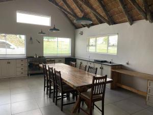 een grote keuken met een houten tafel en stoelen bij The Boathouse in Harrismith