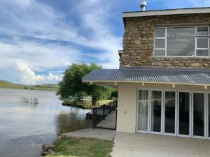 een huis naast een waterlichaam bij The Boathouse in Harrismith