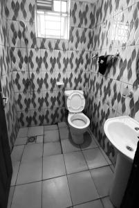 een badkamer met toilet en wastafel bij Le Manoir in Kigali