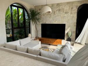 a living room with a couch and a flat screen tv at Villa Shugo Tenshi in Badung