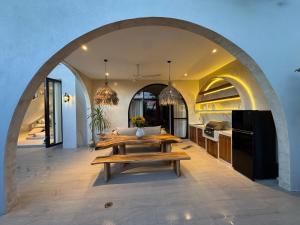 a living room with a table and a kitchen at Villa Shugo Tenshi in Badung
