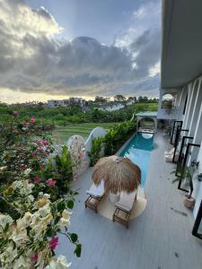een balkon met een zwembad, stoelen en een parasol bij Villa Shugo Tenshi in Badung +30 foto's