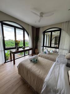 een slaapkamer met twee bedden en een groot raam bij Villa Shugo Tenshi in Badung