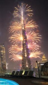 a fireworks display in front of the burj khalifa at GYL Holiday Homes -Imperial Avenue - Luxury Retreat Apt with Burj Khalifa Rooftop View - Near Dubai Mall in Dubai