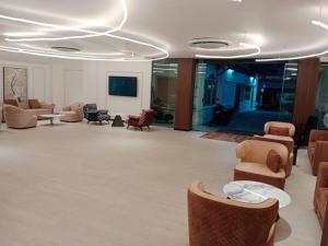 a lobby with couches and chairs in a building at Hotel Soni Mansion Pratunam in Bangkok