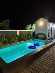 Una piscina en un patio trasero por la noche. en Chettinadu Pool Villa, en Pollachi