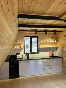 a kitchen with white cabinets and a wooden ceiling at Arsha View in Kazbegi +33 photos