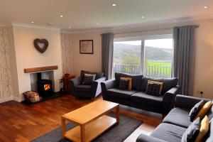 un soggiorno con divano, poltrone e camino di Rhos Helyg ad Amlwch