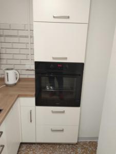een keuken met witte kasten en een zwarte oven bij Ferienhaus in Berenbach in Berenbach