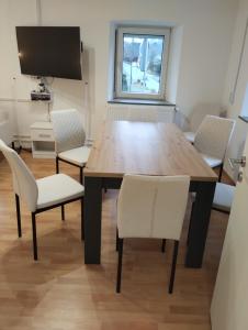 een eetkamer met een houten tafel en stoelen bij Ferienhaus in Berenbach in Berenbach