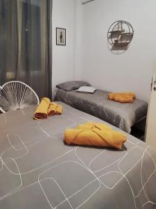 zwei Betten in einem Zimmer mit gelben Laken auf dem Boden in der Unterkunft Milano Apartment - CarliHaus in Mailand