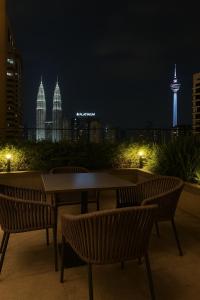 un tavolo con sedie con vista sulla città di notte di Golden Triangle Suites klcc By Majestic a Kuala Lumpur