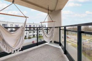 two hammocks on the balcony of a building at Elegant Apartment with Parking Space and Balcony by Noclegi Renters in Gdynia