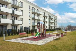 a playground in front of a large building at Elegant Apartment with Parking Space and Balcony by Noclegi Renters in Gdynia