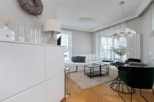 a white living room with a table and a couch at Elegant Apartment with Parking Space and Balcony by Noclegi Renters in Gdynia