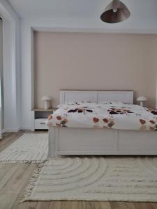 una camera bianca con un letto e un tappeto di Park home a Baia Mare