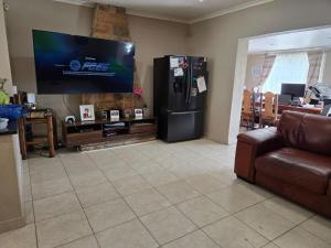 een woonkamer met een grote televisie en een bank bij Nyati in Cape Town