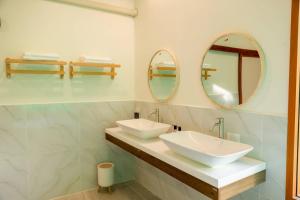 a bathroom with two sinks and two mirrors at Yugen House - Yutaka in Nong Prue