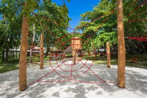 um parque infantil com uma teia de aranha vermelha em um parque em Kempinski Seychelles Resort em Baie Lazare Mahé