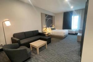 a hotel room with a couch and a bed at La Quinta Inn & Suites by Wyndham Kelowna BC in Kelowna +22 photos