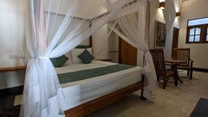 ein Schlafzimmer mit einem Himmelbett in der Unterkunft Bright house in Tangalle