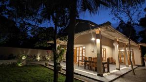 ein kleines Haus mit Essbereich bei Nacht in der Unterkunft Bright house in Tangalle
