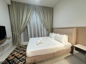 una camera da letto con un letto con due asciugamani bianchi sopra di Golden Triangle Suites klcc By Majestic a Kuala Lumpur
