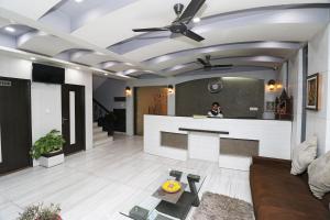 eine Frau, die an einem Tresen im Wohnzimmer steht in der Unterkunft Hotel O Paradise in Rāiwāla