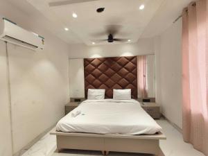 een slaapkamer met een wit bed met een bruin hoofdeinde bij Hotel O Sunrise View in Phagwara