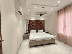 een slaapkamer met een groot bed met een groot hoofdeinde bij Hotel O Sunrise View in Phagwara