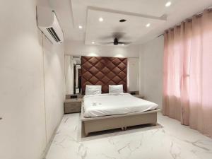 een slaapkamer met een bed met een groot hoofdeinde bij Hotel O Sunrise View in Phagwara +11 foto's