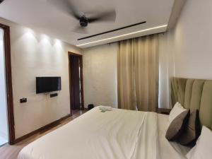 een slaapkamer met een wit bed met een plafondventilator bij Hotel O Sunrise View in Phagwara