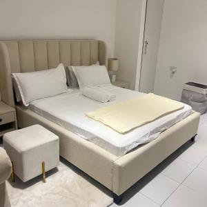 une chambre avec un grand lit avec des draps blancs dans l'établissement PONTOOn STUDIO, à Mombasa