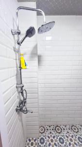 een douche in een badkamer met een witte muur bij Gabala Garden & Mountain View Villa in Gabala +16 foto's
