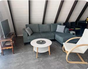 een woonkamer met een bank, een tafel en stoelen bij Gabala Garden & Mountain View Villa in Gabala