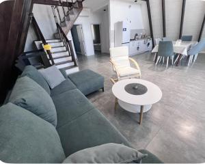 een woonkamer met een groene bank en een tafel bij Gabala Garden & Mountain View Villa in Gabala